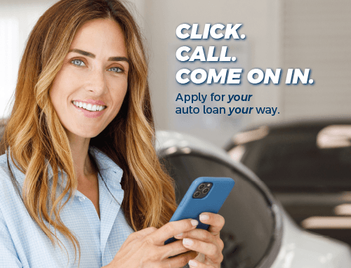 A happy woman outside her car holding a smartphone